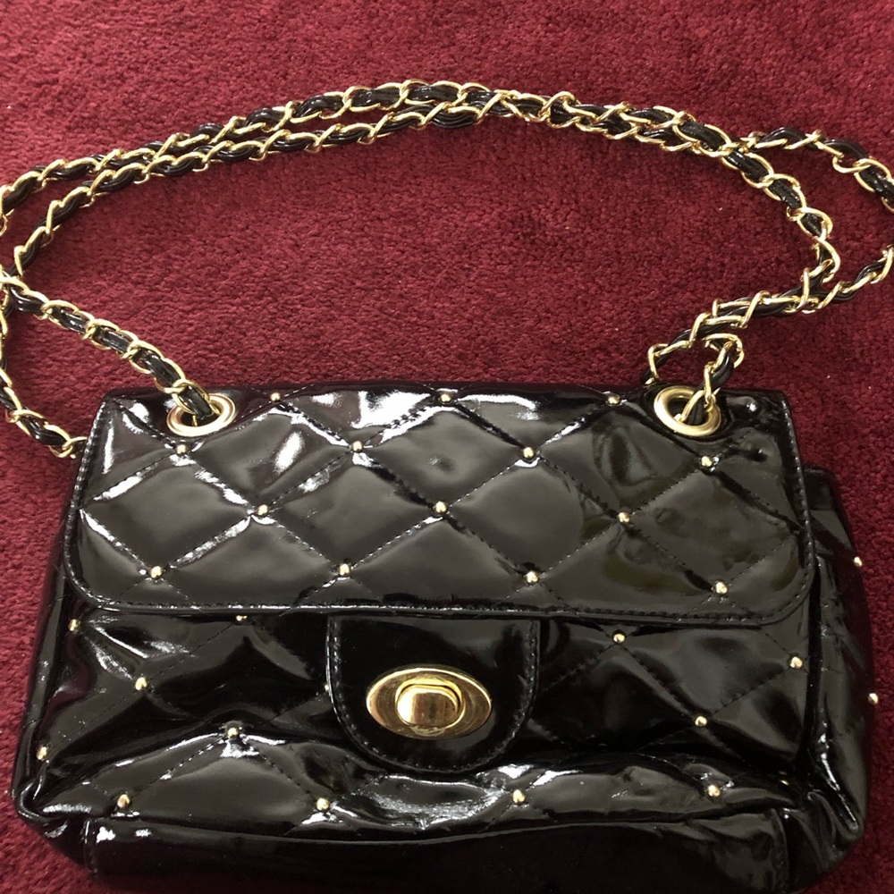 Black patent leather purse with gold studs.